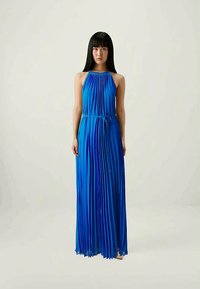 Sininen pleated maxi-mekko, jossa on halter-kaula-aukko ja säädettävä vyötärösolmu. Kankaan pinta on sileä ja siluetti on virtaava.