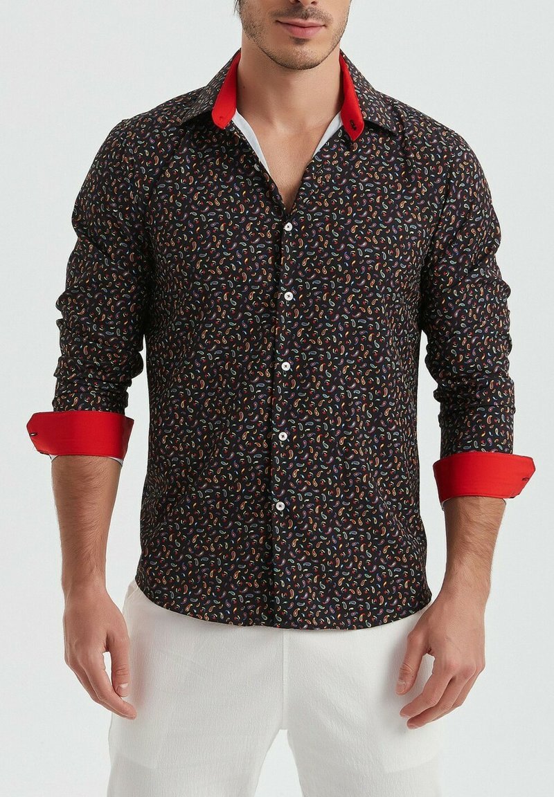 Chemise noire à boutons avec un motif paisley coloré ; col et poignets rouges ; manches longues, design ajusté et texture lisse.