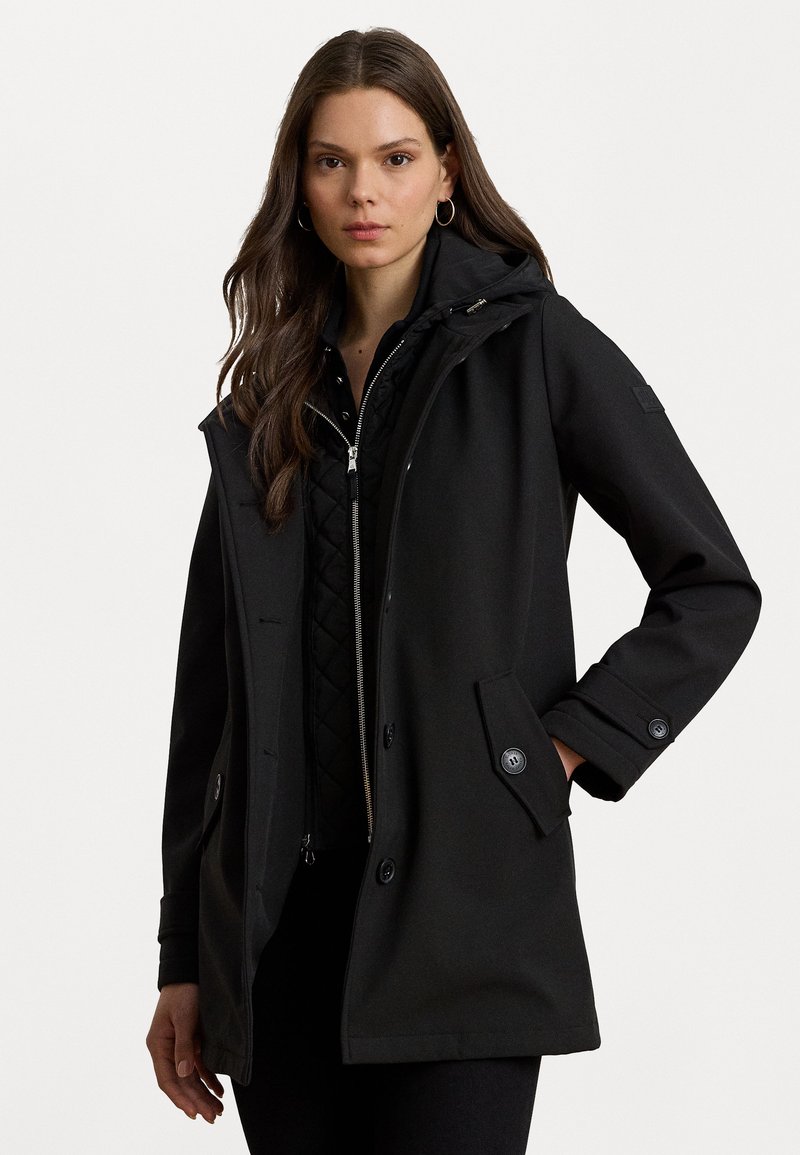 Veste extérieure noire avec capuche, en tissu texturé, fermeture éclair à l'avant et fermetures à bouton. Comprend des poches latérales et une doublure intérieure matelassée.