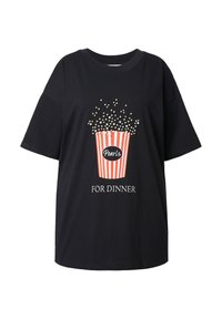 Camiseta negra de gran tamaño con un gráfico de un cubo de palomitas en rojo y blanco. El texto dice "Perlas PARA CENAR" debajo del gráfico.