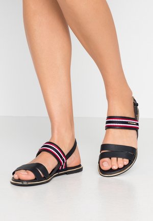 Sorte sandaler med flere stropper, prydet med røde og hvide stribede accenter. Glat lædermateriale med flad sål og åben tå-design.
