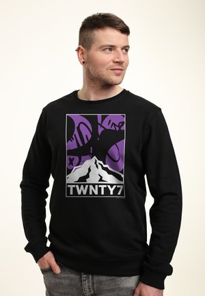 Černá mikina s grafikou, která zobrazuje horu a abstraktní fialové tvary. Na spodní části je výrazně vytištěn nápis "TWNTY7".