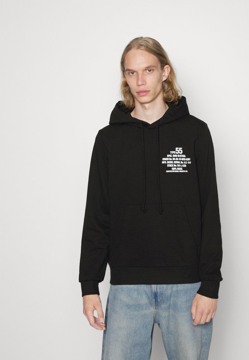 Haut à capuche noir avec une poche frontale, un cordon de serrage, et des détails en texte blanc sur le côté gauche de la poitrine ; tissu doux avec une coupe ample.