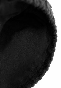 Black textile interior featuring a soft, smooth texture with a slightly rounded edge. The material appears plush and well-stitched.