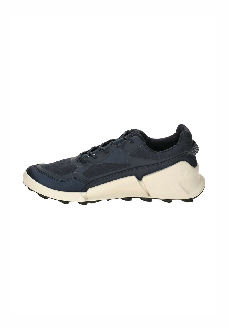 Navy running shoe with a textured upper, lace-up closure, and a thick white midsole. Features a ribbed heel and multiple traction studs on the sole.