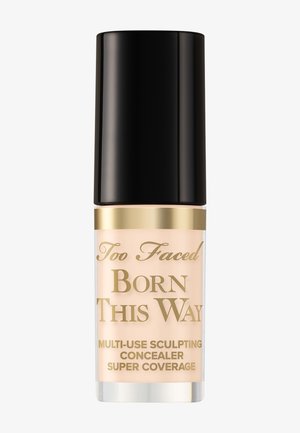 Too Faced Born This Way multi-use Sculpting Concealer in Hellbeige mit schwarzem Deckel und goldener Schrift auf einer durchsichtigen Flasche.