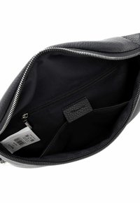 Interno di una borsa nera in pelle con una finitura liscia, dotato di una tasca con zip, foderato in tessuto e con un'etichetta in tessuto testurizzato.