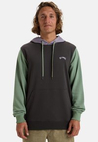 Sudadera con capucha en gris oscuro con mangas verdes y capucha color púrpura claro. Cuenta con un bolsillo frontal y un logo blanco en el pecho.