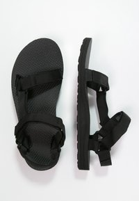 Sandali neri con supporto testurizzato, cinturini in nylon regolabili e suola spessa. Design semplice adatto per un look informale.