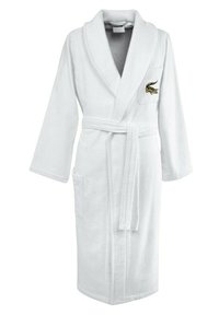 Accappatoio bianco in spugna con colletto a scialle, vita con cintura, due tasche frontali e logo ricamato sul petto sinistro.