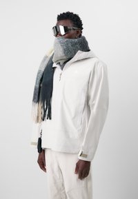 Vit huva jacka med dragkedja, texturerad grå scarf och reflekterande solglasögon. Lätt, slätt tyg; minimalistisk design.