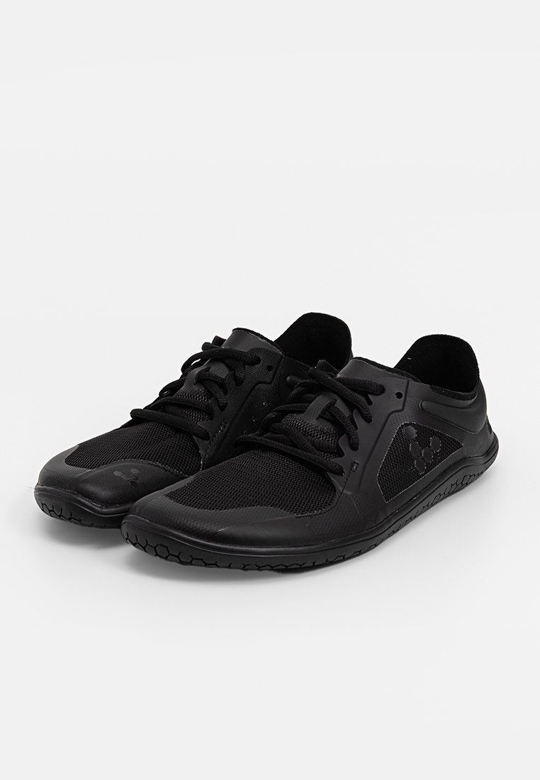 Schwarze Sportschuhe mit einem Mesh-Obermaterial, flacher Sohle und strukturiertem Gummiaußensohle. Besitzt eine Schnürung und ein minimalistisches Design.