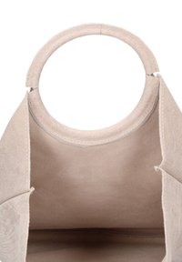 Borsa a mano in suede beige con manico rotondo e design aperto. L'interno è liscio e non foderato con cuciture visibili.