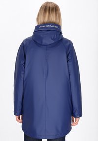 Jūrinis vandeniui atsparus lietpaltis su gobtuvu, tiesaus kirpimo, su spaudėmis ir tekstiniu akcentu ant apykaklės. Lygus, blizgus paviršius.