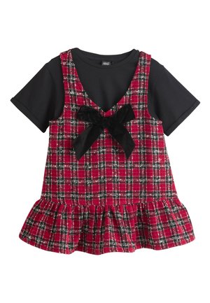 Lyhythihainen musta paita, jonka päällä on punamustan ruutukuvioinen hihaton mekko, jossa suuri musta rusetti ja röyhelöinen helma.