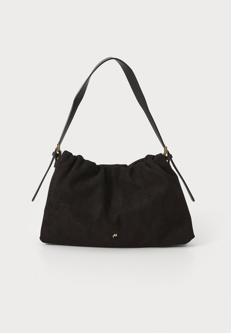 Sac à main en daim noir avec un design froncé, doté d'une sangle en cuir noir et d'un petit logo doré. Texture douce et forme décontractée.
