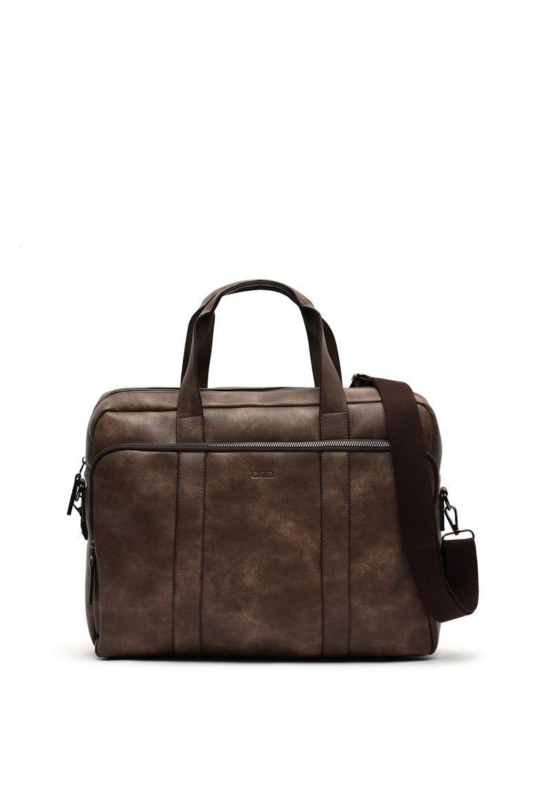 Malette en cuir marron avec double poignée et une bandouillère amovible. Elle dispose d'une fermeture zippée et d'une poche zippée à l'avant.