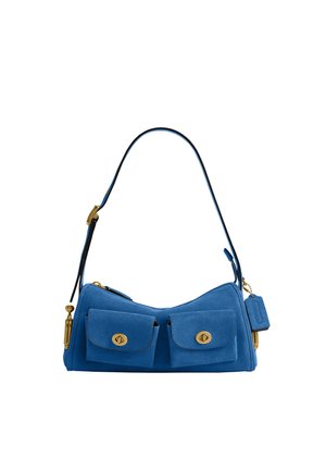 Sac à épaule en daim bleu avec deux poches avant à rabat et fermetures à tour dorées, sangle réglable et étiquette en cuir suspendue.