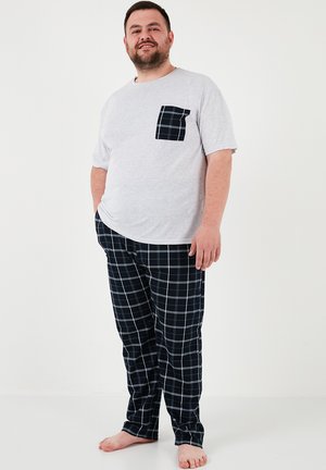 Grå kortærmet skjorte med en sort ternet lomme, parret med sort-hvide ternede pyjamasbukser, alt lavet af blødt stof.