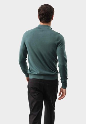 Tyrkysový pletený polo svetr s dlouhými rukávy, žebrovanými manžetami a lemem. Nosený s černými kalhotami; zobrazeno zezadu na neutrálním pozadí.