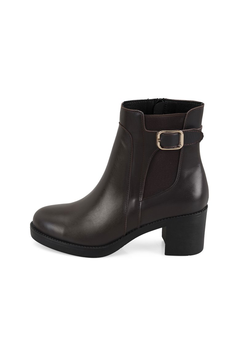 Bottine en cuir marron avec un bout arrondi, un talon bloc modéré, des panneaux latéraux en tissu et une accent décoratif en boucle en métal.