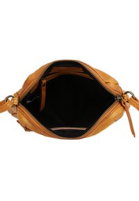 Liten brun läder crossover-väska öppen för att visa svart tyginteriör med ett blixtlåst huvudfack och justerbar axelrem.