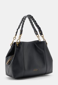 Melnas ādas rokassoma ar teksturētu virsmu, pīto rokturi, zelta tonis aparatūru, rāvējslēdzēja kabatu un logotipa detaļu.