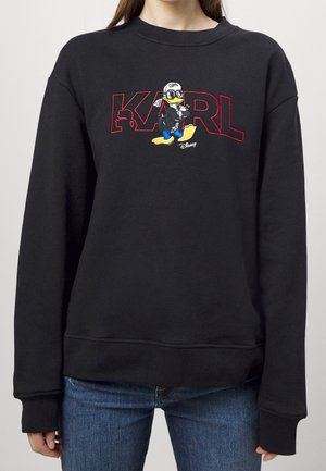 Sweat-shirt noir avec texte contouré en rouge "KARL" et un canard dessin animé portant des lunettes et une veste noire devant le texte.