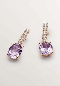 Pendientes de oro rosado con piedras preciosas moradas en forma ovalada y una disposición lineal de piedras claras más pequeñas arriba. Superficie suave, diseño moderno.