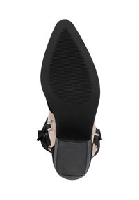 Suela de zapato de tacón alto negro con goma texturizada, punta afilada y detalles de tela beige a lo largo del costado. Presenta un tacón pequeño.