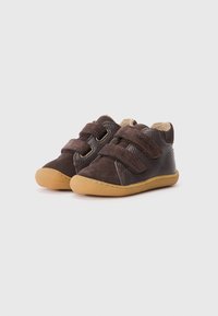 Sapatos de couro castanho com detalhes em camurça e duas tiras de Velcro. Bico redondo e sola em borracha castanha. Forrados com um material suave bege.