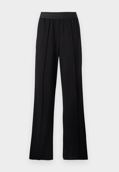 Pantaloni neri a gamba larga realizzati in tessuto morbido con una cintura elastica. Presentano pieghe per un maggiore volume e fluidità, senza motivi o accenti visibili.