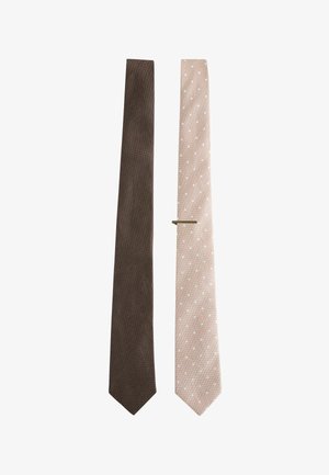 Two men's neckties side by side, one solid brown and the other pale pink with white polka dots and a silver tie clip.