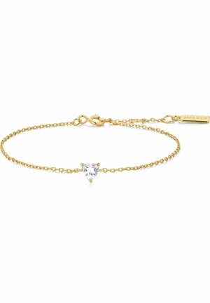 Delicato braccialetto a catena d'oro con un pendente centrale a forma di cuore in pietra preziosa trasparente e una piccola targhetta rettangolare incisa con "ANIA MAJE".