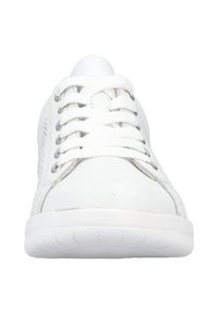 Valkoiset kangaskengät, joissa on rei'itetyt sivut, litteät nauhat ja hopeiset rei'ät. Pyöreä kärki ja teksturoitu kumipohja. Minimalistinen muotoilu.