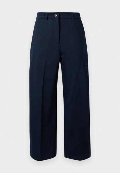 Marineblaue weit geschnittene Hose aus Baumwolle mit flacher Vorderseite, Knopfverschluss und zwei gefalteten Taschen vorne.