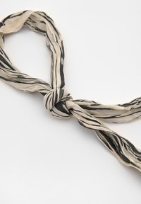Écharpe à motif beige et noir en tissu doux et léger, tournée et nouée au centre, arborant un design abstrait à rayures.