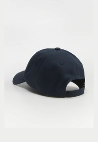 Granatowa czapka baseballowa wykonana z bawełny, z zakrzywionym daszkiem, regulowanym paskiem z tyłu i detalami przeszycia na czole.