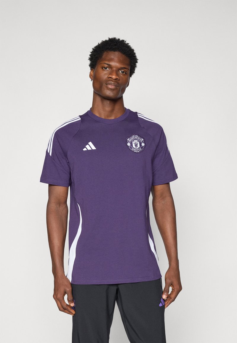 Paarse sportshirt met witte zijpanelen en het Adidas-logo op de rechter schouder. Het Manchester United-embleem is op de borst afgebeeld.