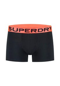 Pantaloni boxer neri con una larga cintura elastica arancione che presenta il testo "SUPERDRY" in nero. Tessuto liscio, design aderente e senza motivi visibili.