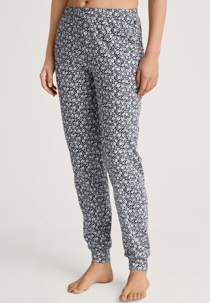 Zwart-witte bloemenprint pyjamabroek met een aansluitende enkellengte en een elastische tailleband, gemaakt van zachte, lichte stof.