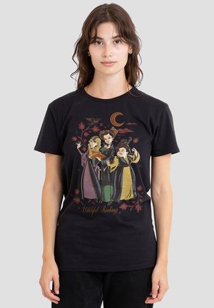 Schwarzes Baumwoll-T-Shirt mit einem grafischen Design von drei Hexen. Die Farben umfassen Grün, Lila und Gelb, mit dem Text "Witchful Thinking".