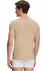 Beige shirt met korte mouwen en een ronde halslijn. Gladde, aansluitende stof, met een naadloos ontwerp en minimale zichtbare stiksels.