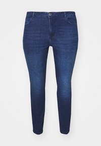 Sötétkék, slim-fit farmernadrág elülső gombbal és zsebekkel, fehér háttér előtt, elölnézetből bemutatva.