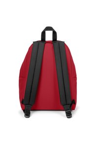 Sac à dos rouge avec des bretelles rembourrées noires et une poignée en haut. Présente une forme arrondie et une texture de tissu lisse. Convient pour un usage quotidien.