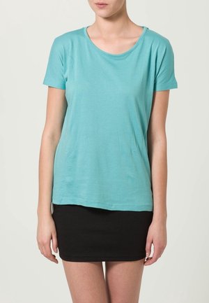 Licht teal shirt met korte mouwen, gemaakt van zachte stof, met een ronde halslijn en een losse pasvorm, gecombineerd met een zwarte strakke rok.