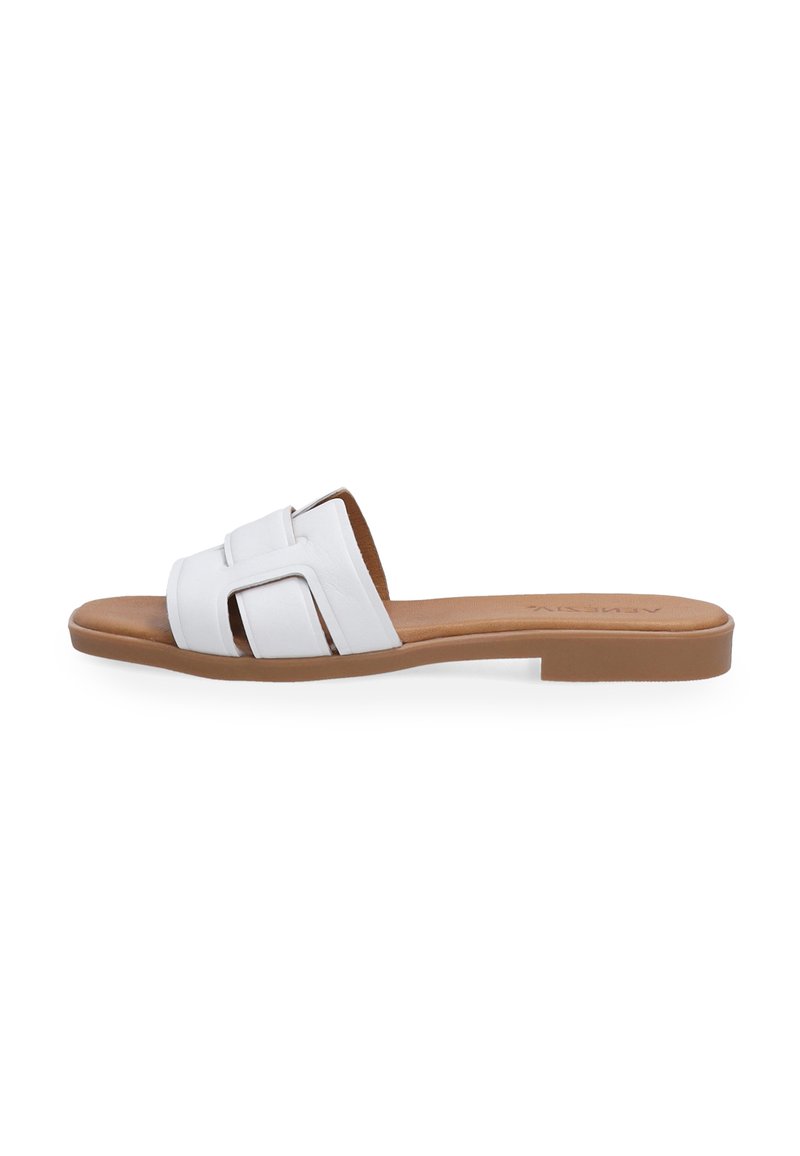 Hvid lædersandal med flade brun sål og to overlappende remme i et minimalistisk design. Glat tekstur med en enkel æstetik.