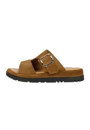 Brązowa zamszowa sandałka na płaskiej podeszwie z szerokimi paskami, dużą srebrną klamrą, wyściełaną wkładką i czarną teksturowaną gumową podeszwą.