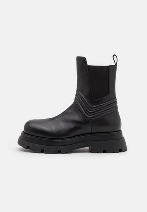 Botte mi-mollet en cuir noir avec panneau latéral élastique, languette de traction, semelle rembourrée et semelle extérieure crantée pour l'adhérence et la durabilité.
