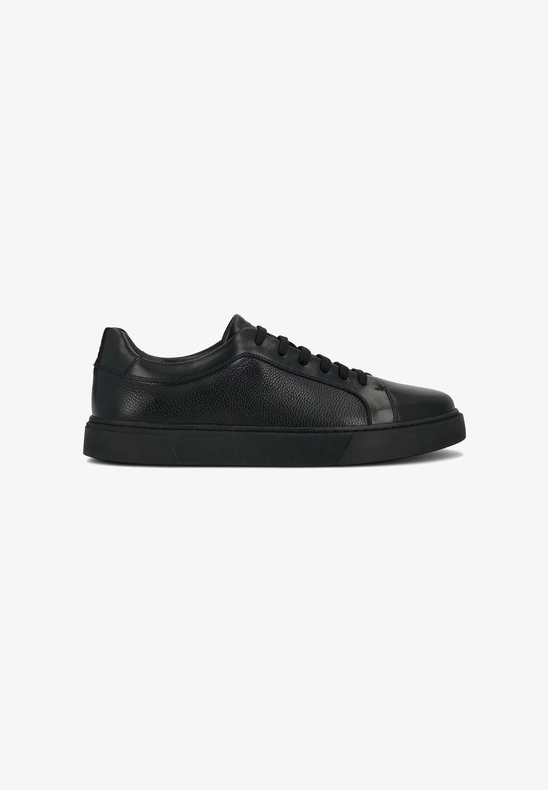 Baskets basses en cuir noir avec panneaux latéraux texturés et semelle en caoutchouc noire, vues de l'extérieur avec les lacets noués.
